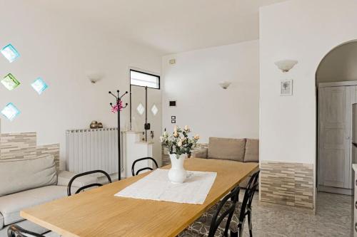 a dining room table with a vase of flowers on it at R-House - Appartamento in Collecorvino