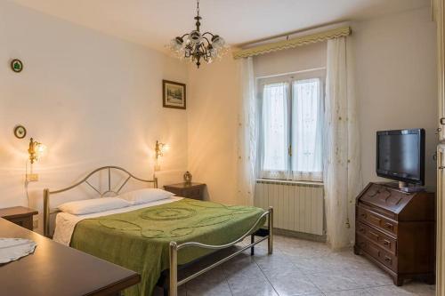 1 dormitorio con 1 cama, TV y mesa en R-House - Appartamento, en Collecorvino