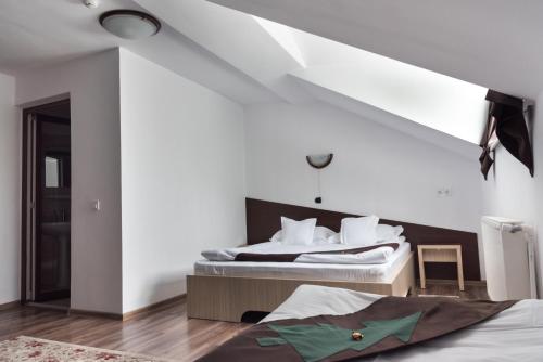 a bedroom with two beds with white walls at Casa Bradul Voronet in Gura Humorului