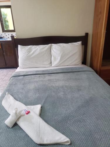 a bed with two white socks and a pair of shoes at Beach Side Condos Caye Caulker by CCVH in Caye Caulker