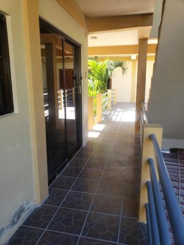 a corridor of a building with blue chairs and a door at Beach Side Condos Caye Caulker by CCVH in Caye Caulker