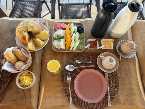 a wooden table with plates of food on it at Pousada Lá em Casa in Barra Grande