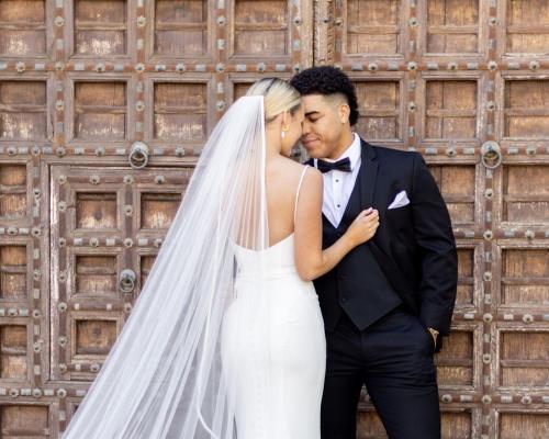 a bride and groom kissing in front of a wooden wall at Omni Scottsdale Resort & Spa at Montelucia in Scottsdale