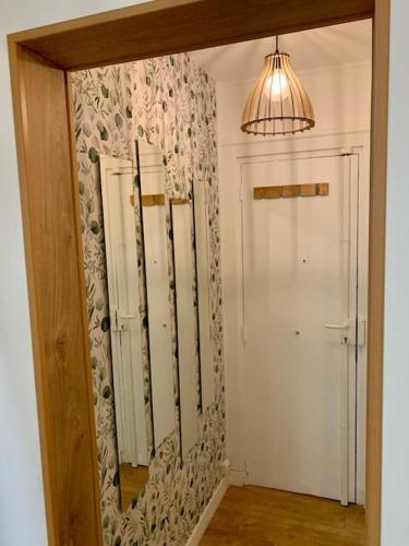 un miroir dans une pièce avec une porte et une lampe dans l'établissement Agréable 2 pièces à Pantin, à Pantin