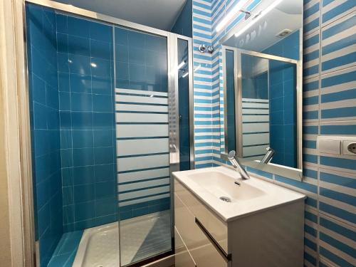ein blau gefliestes Bad mit einem Waschbecken und einer Dusche in der Unterkunft Bonito apartamento en Utrera WIFI gratis in Utrera