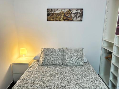 ein Schlafzimmer mit einem Bett und einem Bild an der Wand in der Unterkunft Bonito apartamento en Utrera WIFI gratis in Utrera
