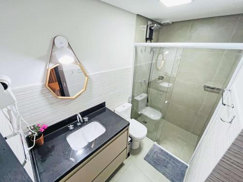 y baño con ducha, lavabo y espejo. en Studio Mar Casado Guarujá Brasil en Guarujá