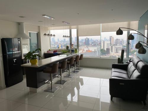 a kitchen with a bar with chairs and a view of the city at WTC Suites in Mexico City