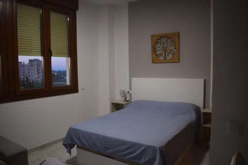 sypialnia z łóżkiem i oknem w obiekcie LUX-Palacio Fibes w Sewilli