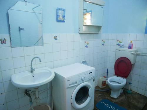 a bathroom with a washing machine and a sink at Masula Homes in Mombasa