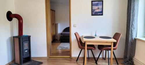 um quarto com uma mesa e cadeiras e um fogão a lenha em Suhl - Ihre erholsame Wohnung in Zentrumnähe em Suhl