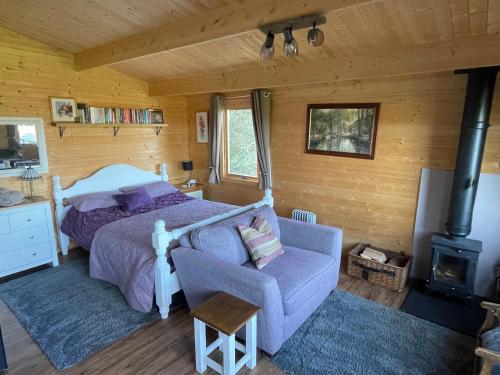 um quarto com uma cama, uma cadeira e um fogão em Cosy cabin in Annie’s meadow em West Meon