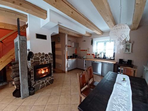 a kitchen with a table and a fireplace in a room at Trzy Strumyki in Kąty Bystrzyckie