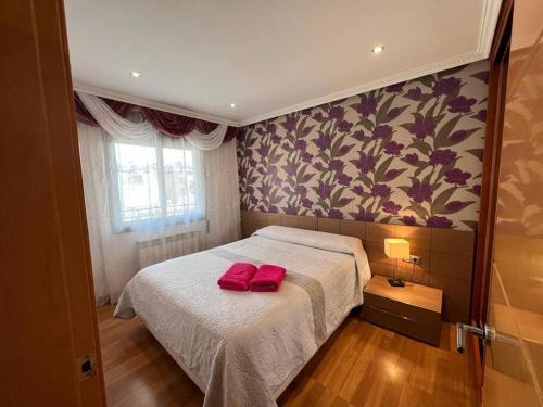 1 dormitorio con 1 cama con 2 almohadas rojas en Cozy apartment for 6 people - Port Aventura en Vilaseca