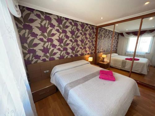 a bedroom with two beds and a pink towel on the bed at Cozy apartment for 7 people - Port Aventura in Vila-seca