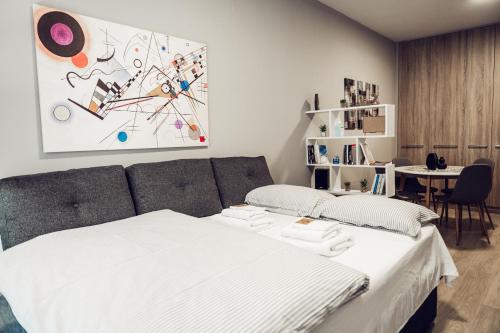 una camera con un letto, un tavolo e un quadro di Axd DownTown Spacious Lux Apartment a Alexandroupoli
