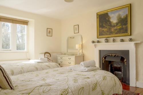 a bedroom with two beds and a fireplace at Castle Lodge Haughton Castle in Hexham