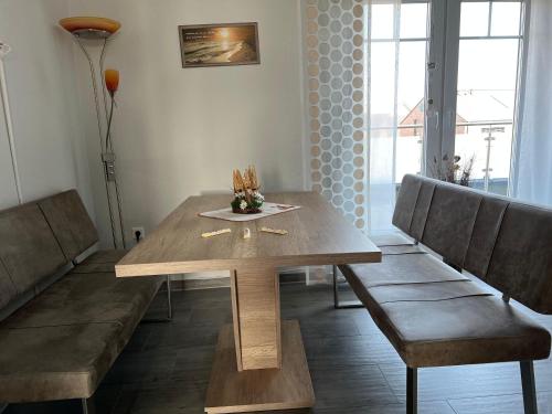 einen Holztisch und zwei Stühle in einem Zimmer in der Unterkunft Ferienwohnung Nordsee in Krummhörn
