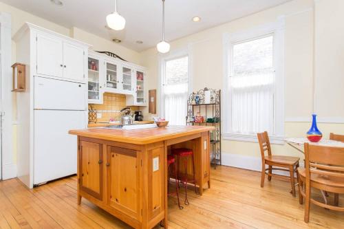 a kitchen with a wooden island and a white refrigerator at iKlektik House // Cardinal in Chicago