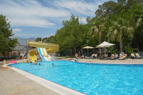 a pool with a slide and people in the water at MIRAMOR HOTEL & Spa - ULTRA ALL INCLUSIVE SELECTION in Kemer