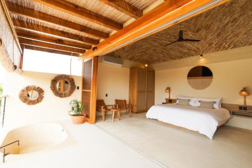 a bedroom with a large bed and a table at Casa Borka in Puerto Escondido