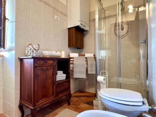 a bathroom with a toilet and a glass shower at La Casina di Nada in Massa Martana