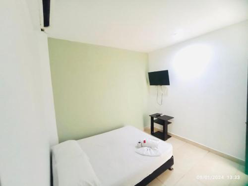Kleines weißes Zimmer mit einem Bett und einem TV in der Unterkunft Laurel plaza in Montería
