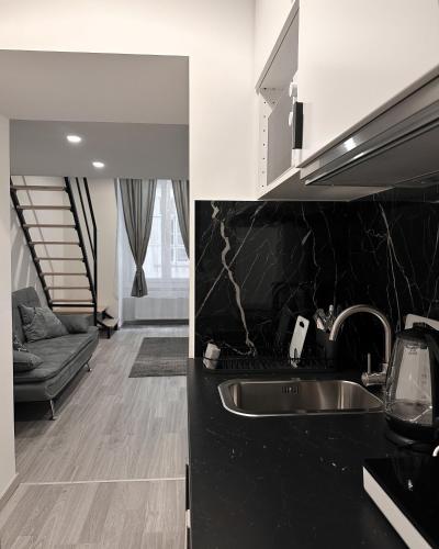 a kitchen with a sink and a living room at Dolce Vita Basilica in Budapest