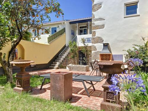 a patio with a table and benches in front of a house at Villa Victoria in Caminha