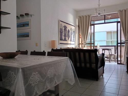 uma sala de jantar com mesa e cadeiras e um quarto com varanda em Apartamento charmoso em frente a praia em Cabo Frio em Cabo Frio