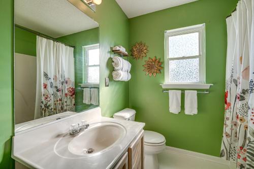 a green bathroom with a sink and a toilet at Charming Nags Head Retreat Half-Mi to State Park! in Nags Head