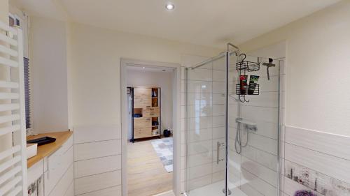 ein Bad mit einer Dusche und einer Glastür in der Unterkunft Lillis Cottage in Goslar