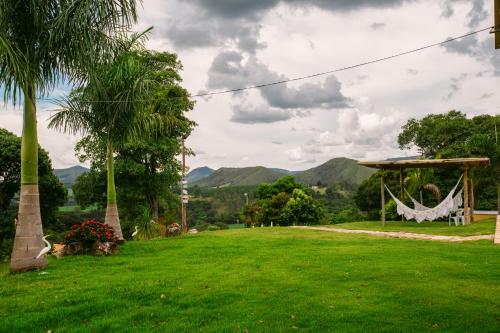 a garden with a hammock and a gazebo at Pousada Mirante dos Ipês - Capitólio - MG in Capitólio