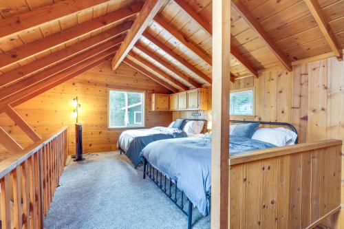 a bedroom with two beds in a log cabin at Cozy Mi-Wuk Village Cabin 18 Mi to Dodge Ridge! in Mi-Wuk Village