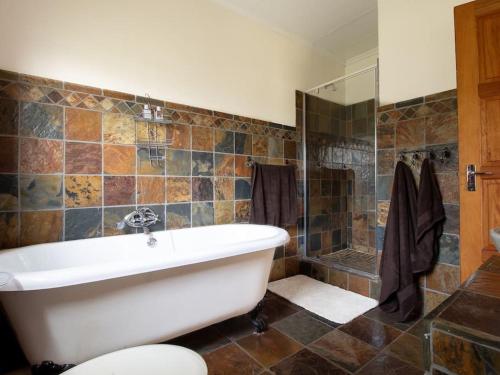 a large bathroom with a tub and a shower at Lilly’s-place in Sabie