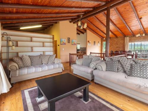 a living room with white couches and a table at Lilly’s-place in Sabie