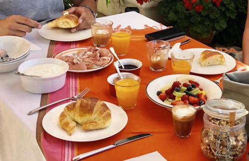 een tafel met borden met ontbijtproducten en drankjes bij La Cour des Délices in Gigny