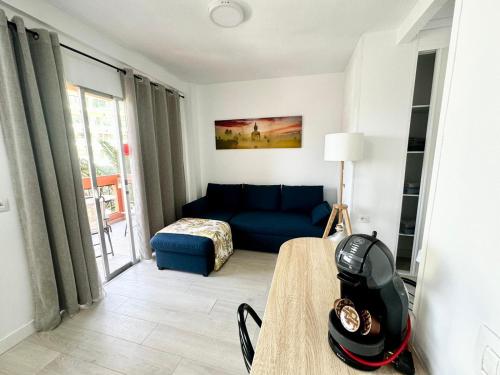 a living room with a blue couch and a table at Ocean Breeze Oasis in Puerto de la Cruz in Puerto de la Cruz