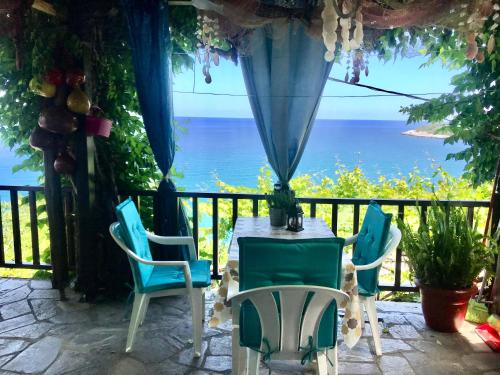 a table and chairs on a patio with a view of the ocean at Daenerys Home in Agios Ioannis Papa Nero in Agios Ioannis Pelio