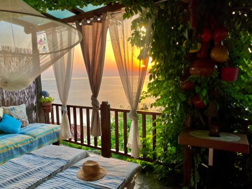 a balcony with a bed and a view of the ocean at Daenerys Home in Agios Ioannis Papa Nero in Agios Ioannis Pelio