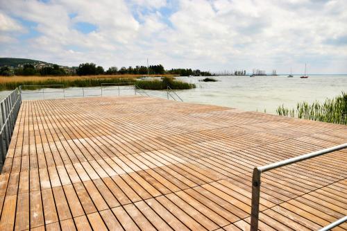 a wooden dock next to a body of water at Olive Apartman in Alsóörs