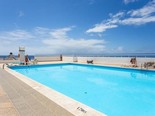 a swimming pool with the ocean in the background at Hola ola Bajamar in Bajamar