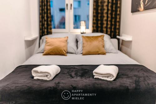 een slaapkamer met een bed met twee handdoeken erop bij Happy Day - Happy Apartamenty Mielec in Mielec