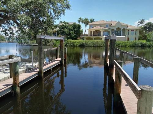 a house on the water with a dock at Iguana Updated Home By Large Imperial River 1 Mi to Beach in Bonita Springs