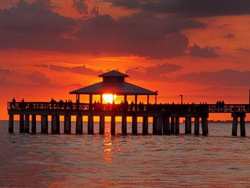 a pier with the sun setting over the water at Iguana Updated Home By Large Imperial River 1 Mi to Beach in Bonita Springs