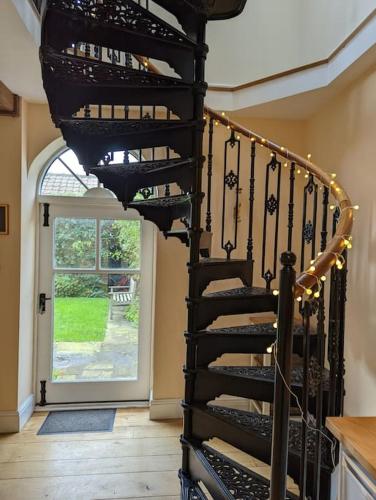 a spiral staircase in a house with a window at Skipton House Annex in Thirsk