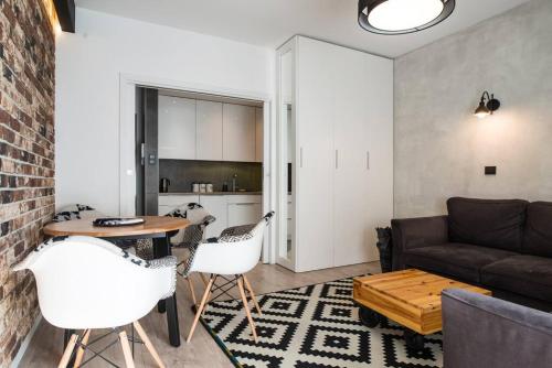 Una sala de estar con un sofá, una mesa y sillas. en Apartament nad Wisłą, bezpłatny parking, AWG APARTMENTS, en Cracovia