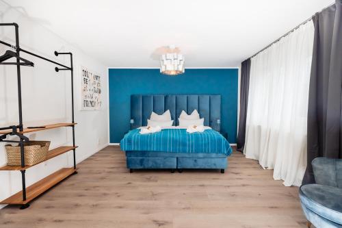 a blue bedroom with a bed and a blue wall at bee Apartments Design NESPRESSO Küche Parkplätze PS5 in Aachen