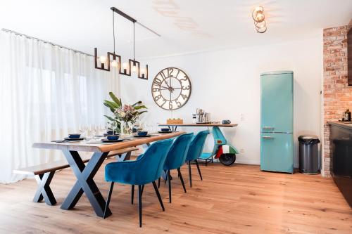 a dining room with a table and blue chairs at bee Apartments Design NESPRESSO Küche Parkplätze PS5 in Aachen