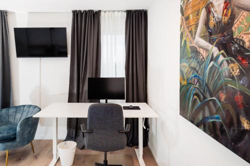 a room with a desk with a computer and two chairs at bee Apartments Design NESPRESSO Küche Parkplätze PS5 in Aachen